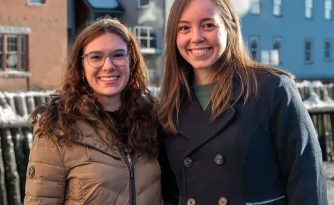 Two women pose in front of the Portland waterfront